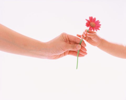 花を渡す母と子の手