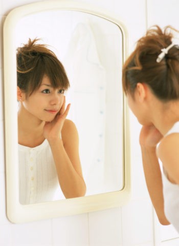 バスルームで鏡を見る女性