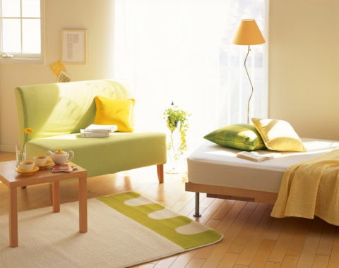 窓辺のグリーンソファーとベッド