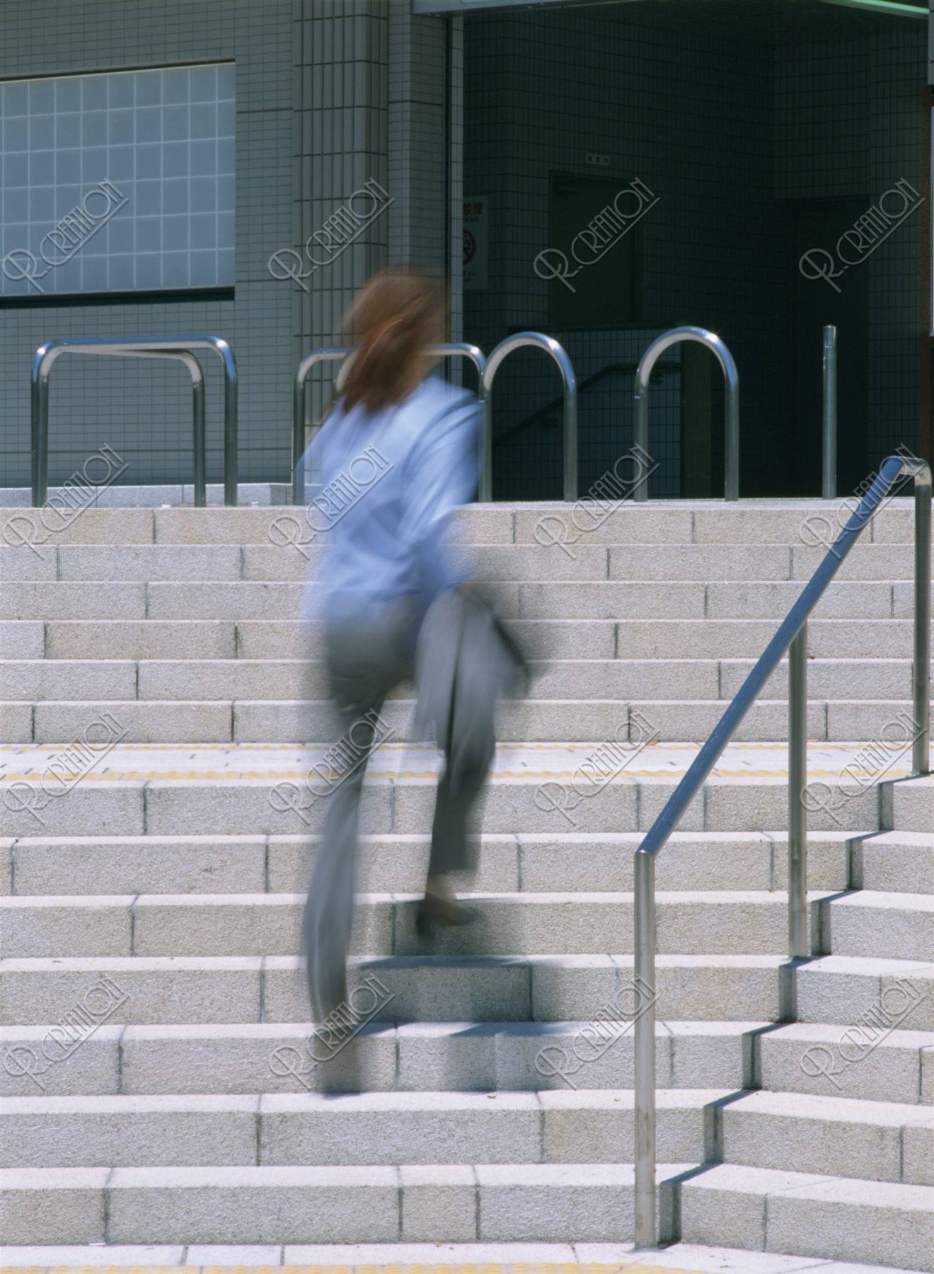 階段を上がるビジネスの女性