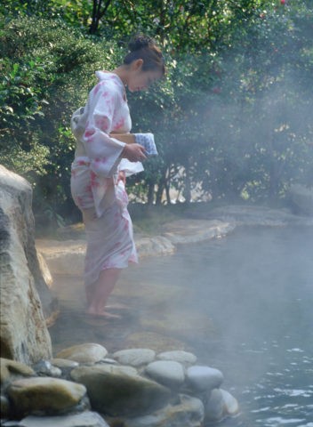 露天風呂で桶を持つ女性