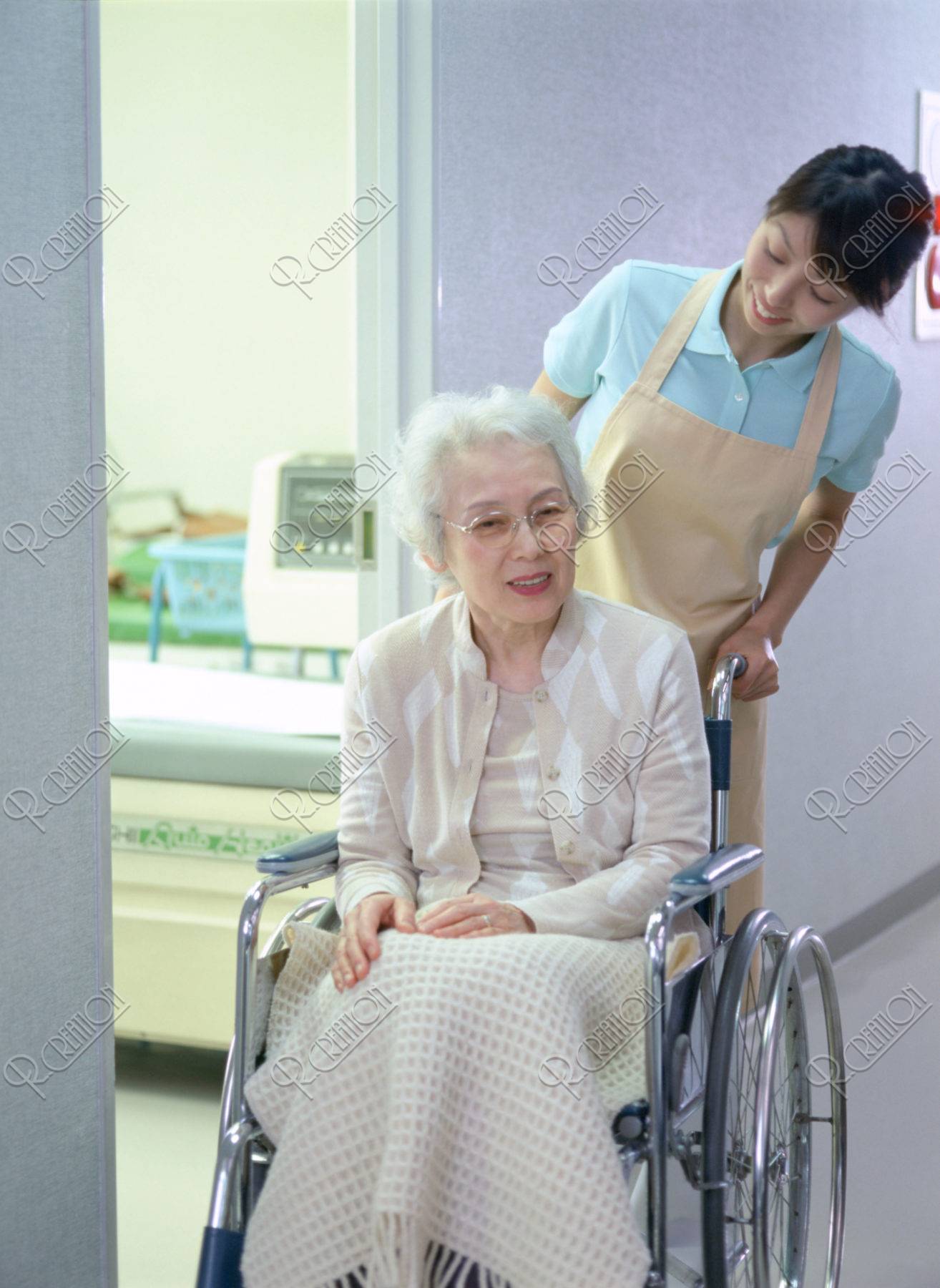 車椅子のお年寄りと介護人