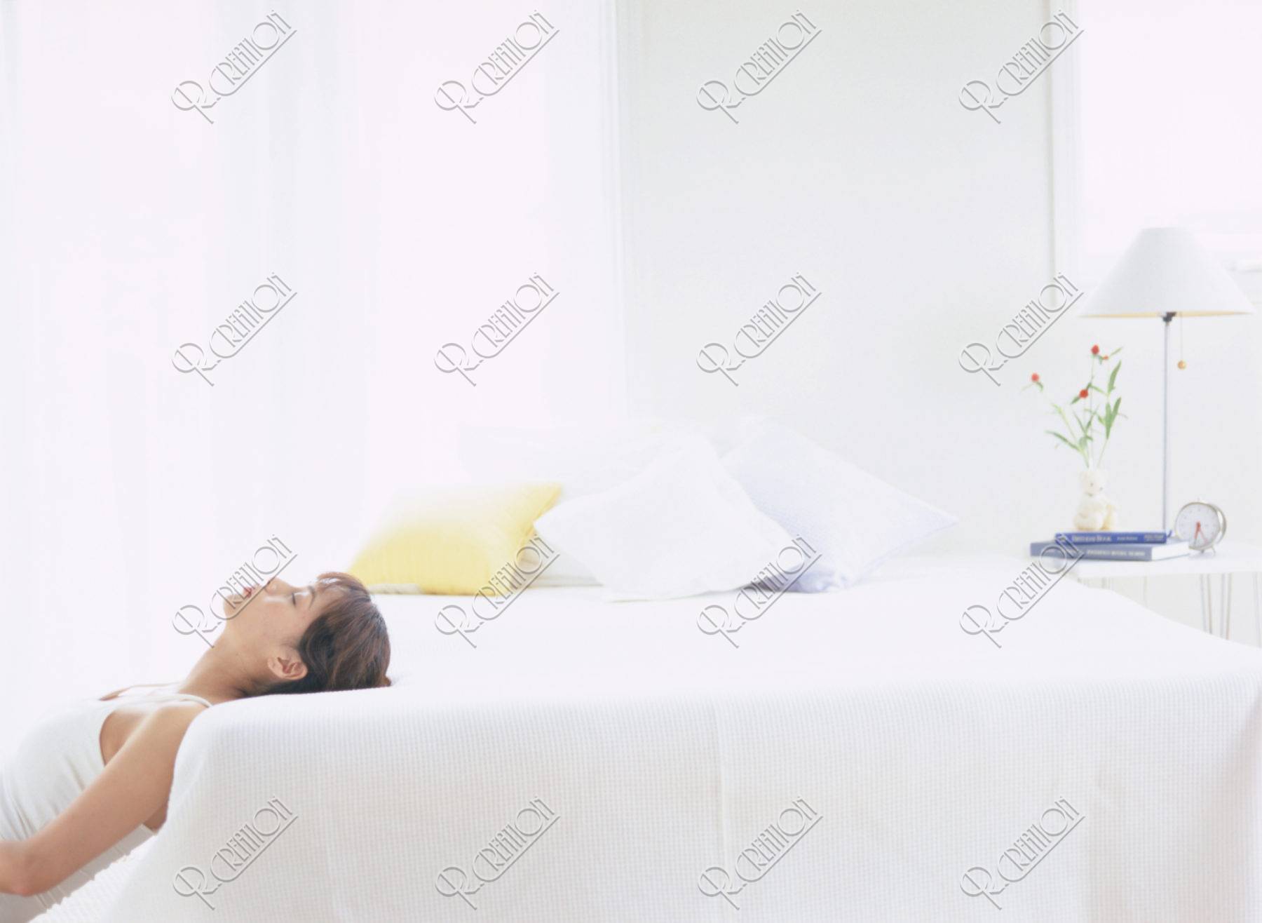 ベッドに頭を乗せる女性