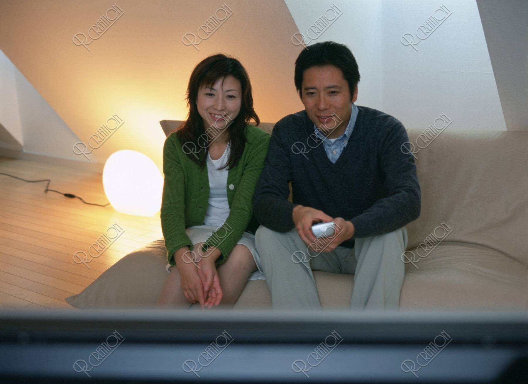 プラズマテレビを見るカップル