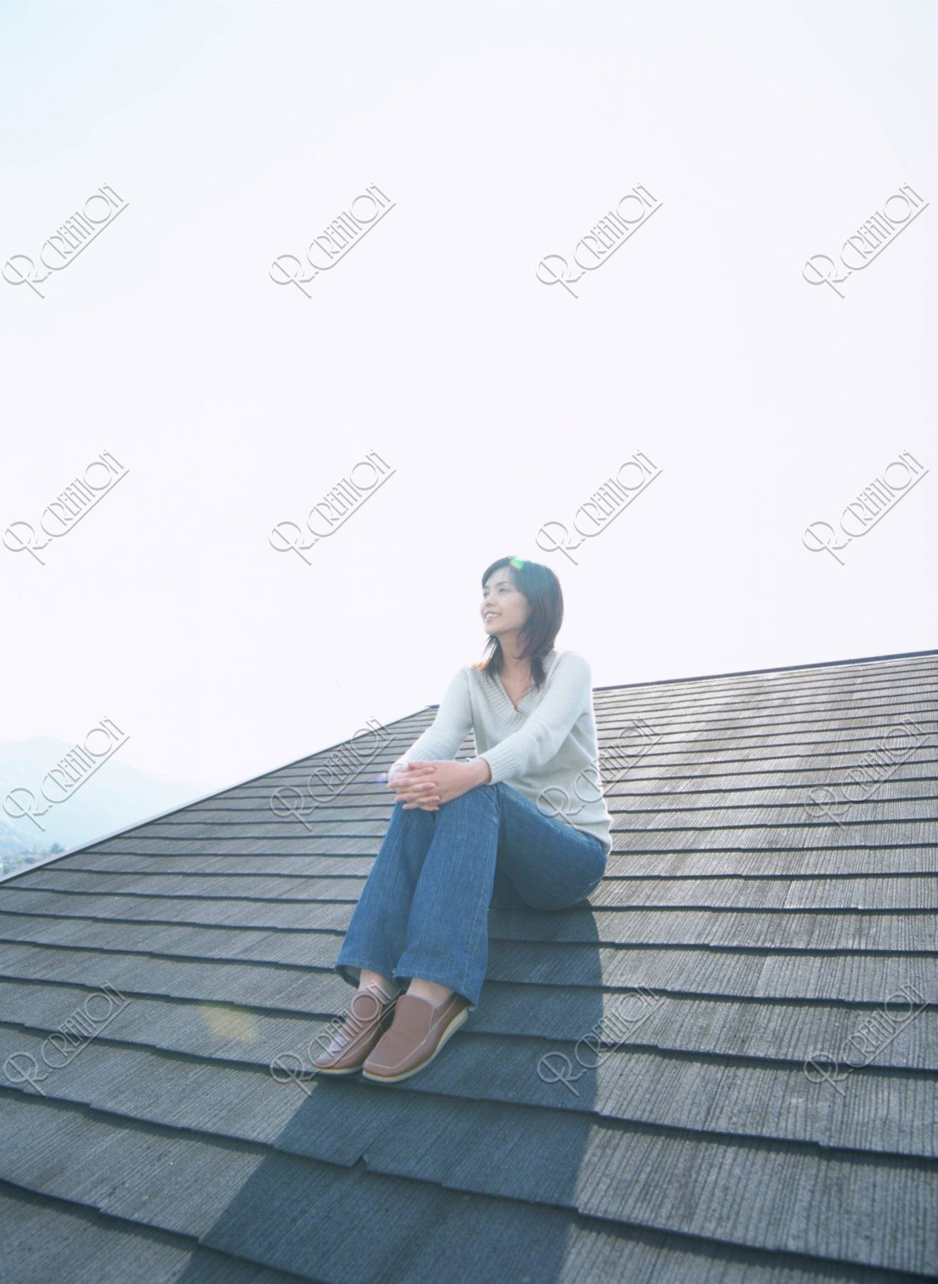 屋根に座る女性