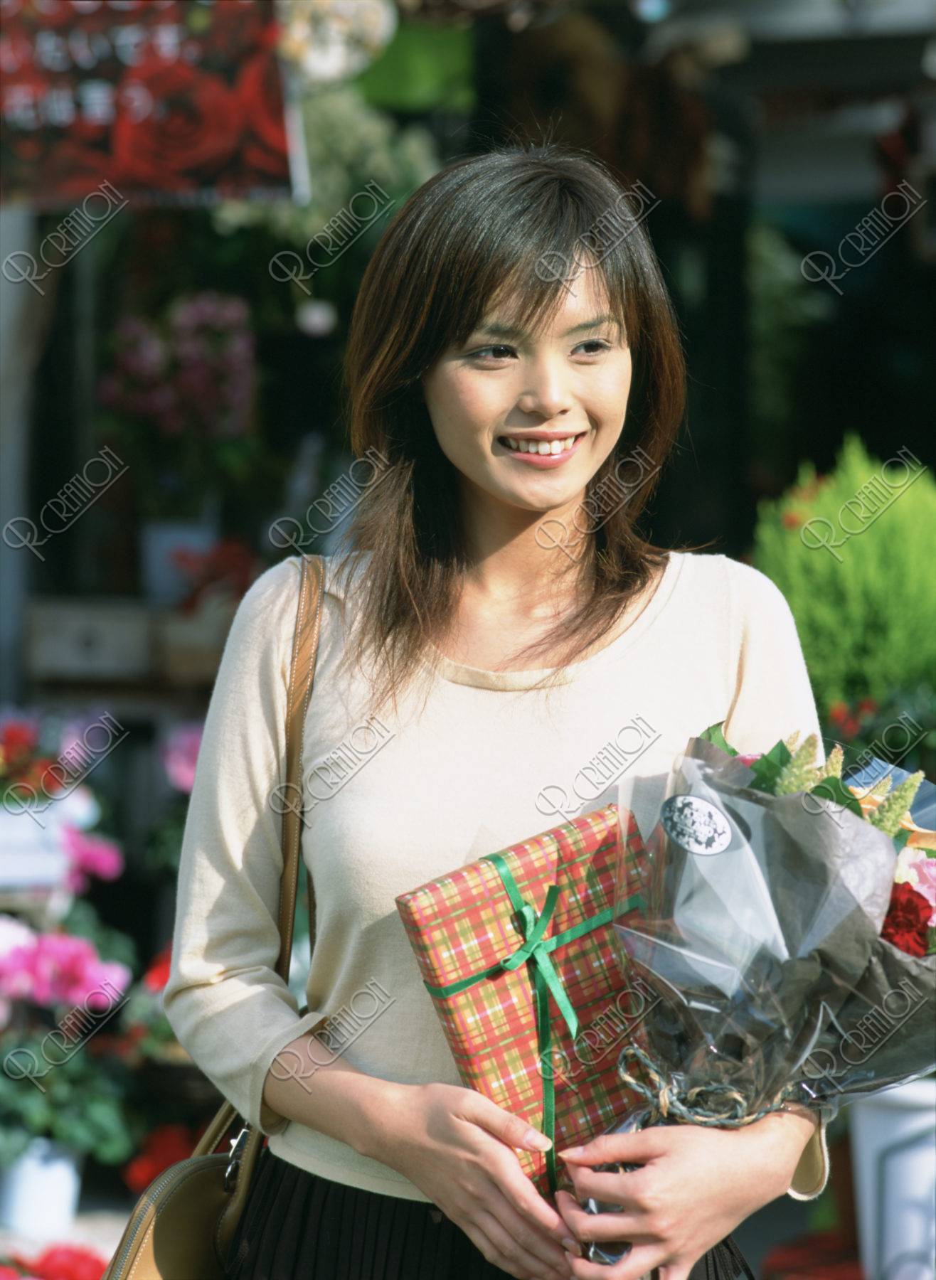花とプレゼントを持つ女性