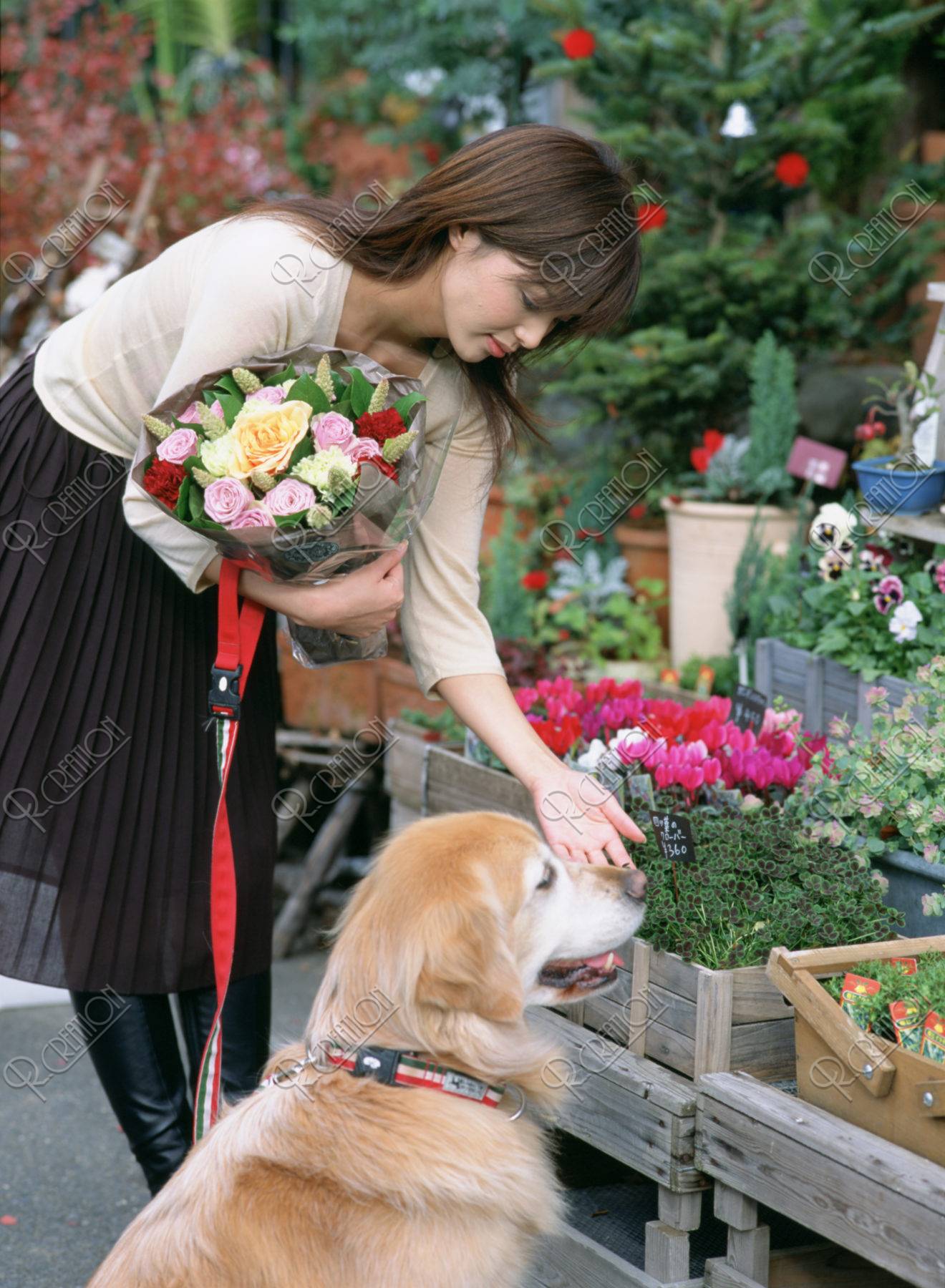 花屋の前の女性と犬