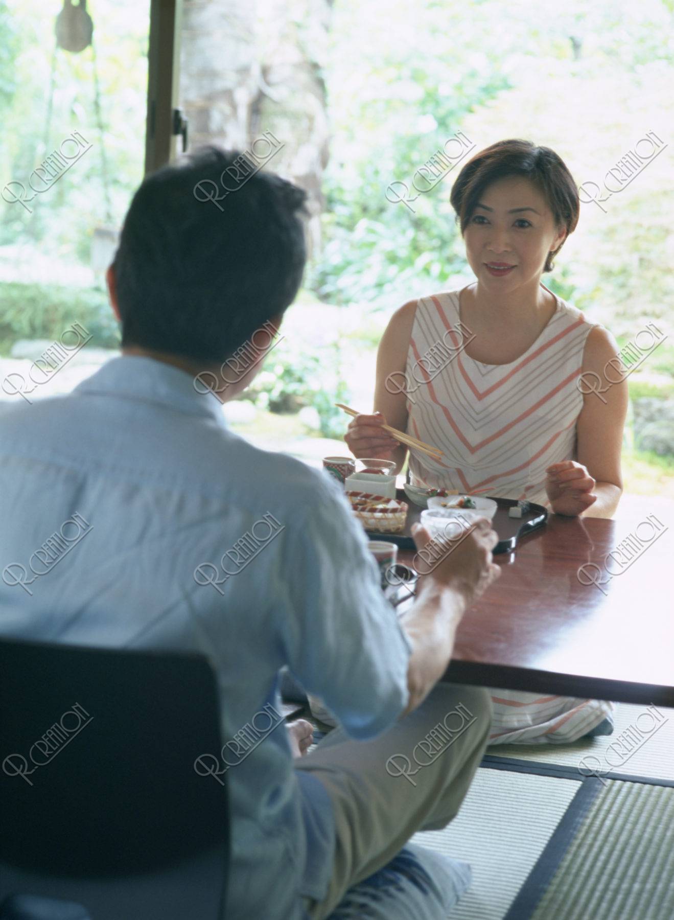 和室で食事する熟年夫婦