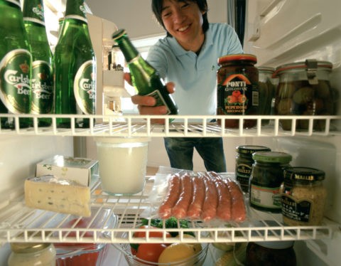 冷蔵庫からビールを取る男性