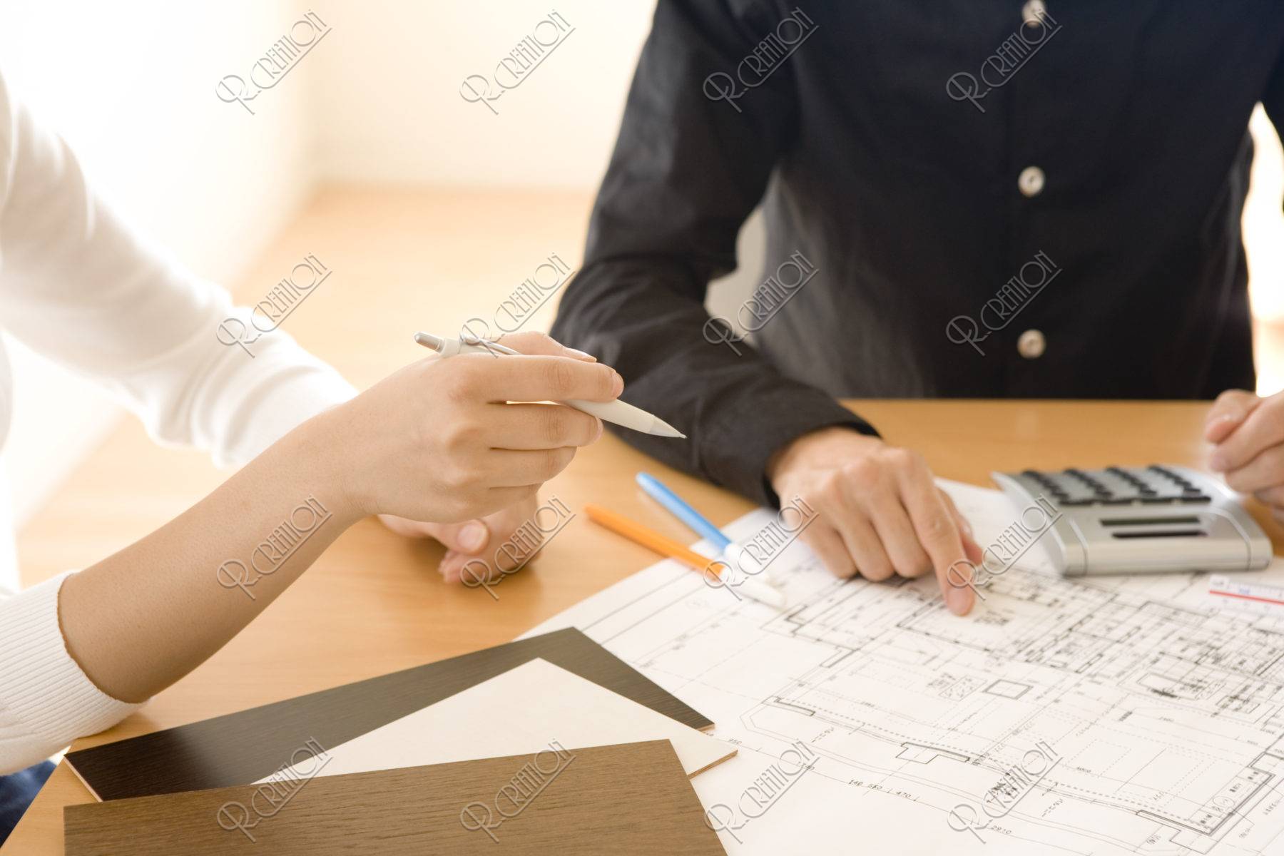 設計図を見る男性と女性の手