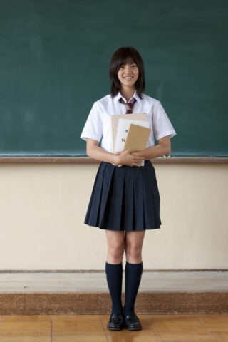 黒板の前に立つ女子高校生